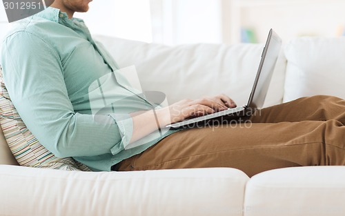 Image of close up of man working with laptop at home