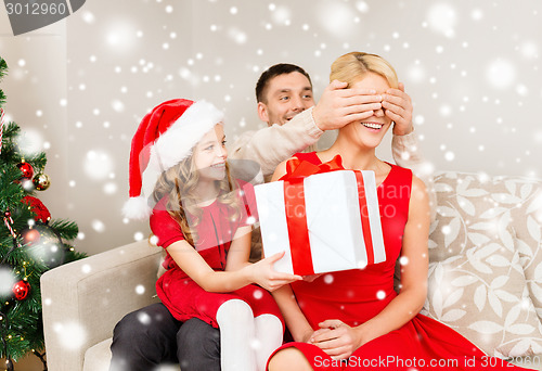 Image of smiling family with gift box