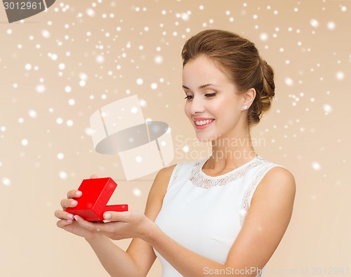 Image of smiling woman holding red gift box