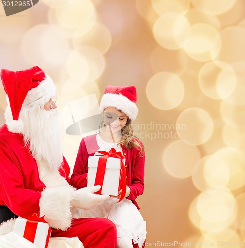 Image of smiling little girl with santa claus and gifts