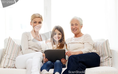 Image of smiling family with tablet pc at home