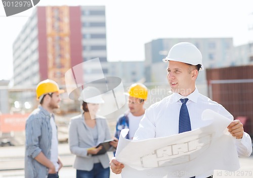 Image of group of builders with tablet pc and blueprint