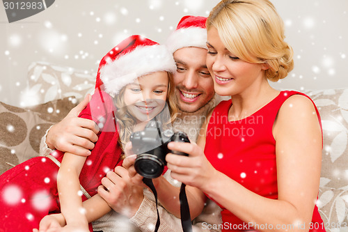 Image of happy family with digital camera at home