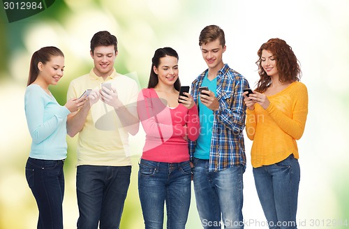 Image of group of smiling teenagers with smartphones