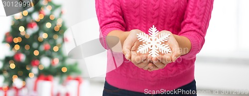 Image of close up of woman holding snowflake decoration