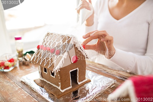 Image of close up of woman making gingerbread houses