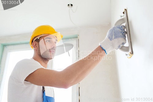 Image of builder working with grinding tool indoors