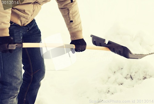 Image of closeup of man shoveling snow from driveway