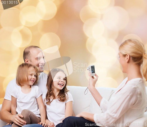 Image of happy family with camera at home