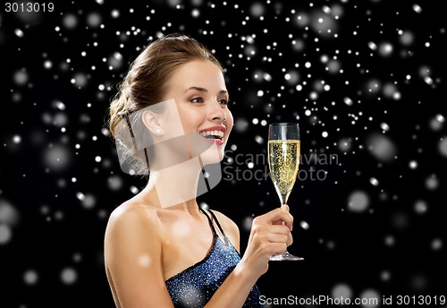 Image of smiling woman holding glass of sparkling wine