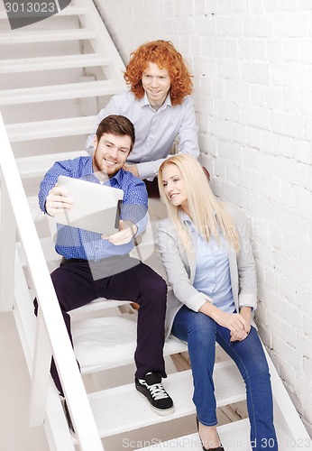 Image of team with tablet pc computer sitting on staircase