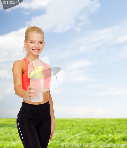 Image of smiling sporty woman with protein shake bottle
