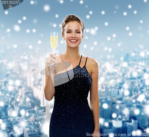 Image of smiling woman holding glass of sparkling wine