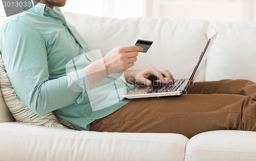 Image of close up of man with laptop and credit card