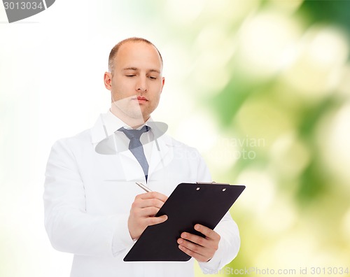 Image of serious male doctor with clipboard