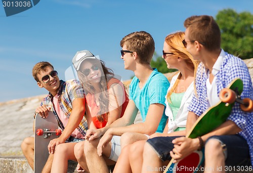 Image of group of smiling friends sitting on city street