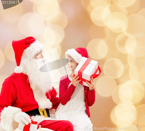 Image of smiling little girl with santa claus and gifts