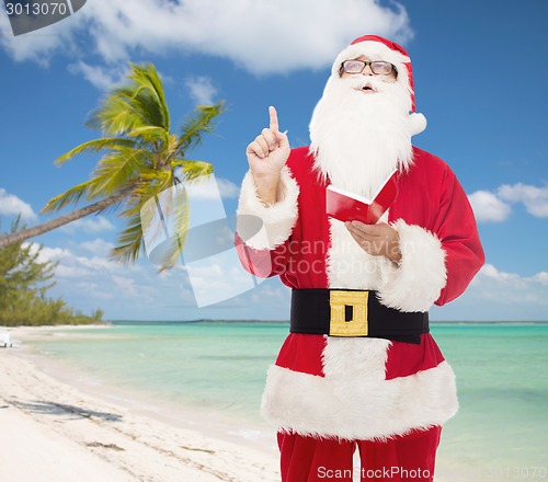 Image of man in costume of santa claus with notepad