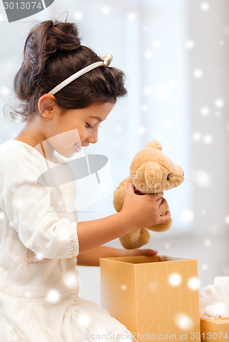 Image of smiling little girl with gift box and toy