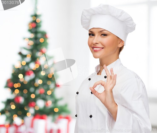 Image of smiling female chef showing ok sign