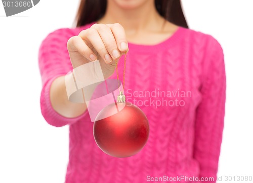 Image of close up of woman in sweater with christmas ball