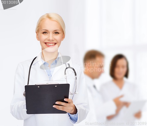 Image of smiling female doctor with clipboard