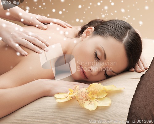 Image of beautiful young woman in spa salon getting massage