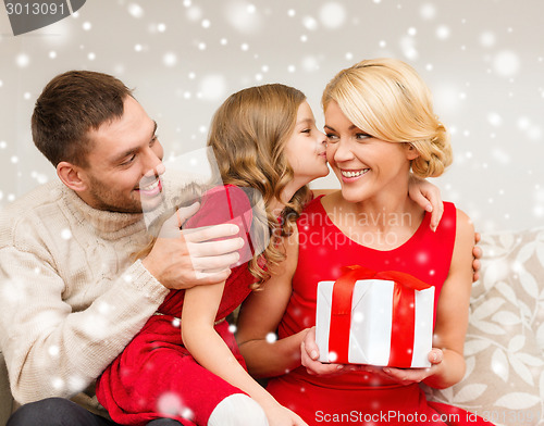 Image of smiling family holding gift box