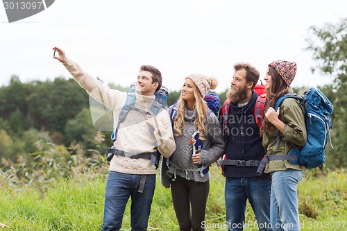 Image of group of friends with backpacks taking selfie