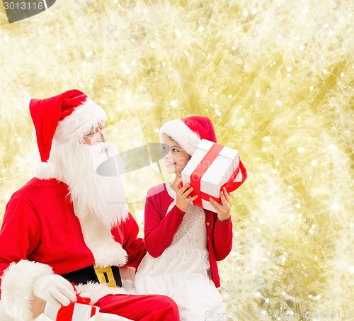 Image of smiling little girl with santa claus and gifts