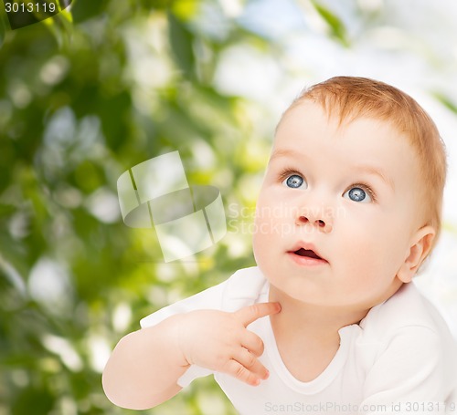 Image of curious baby lying on floor and looking up