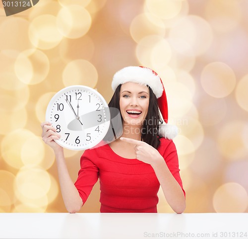 Image of smiling woman in santa helper hat with clock