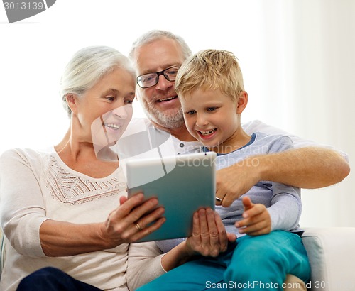Image of smiling family with tablet pc at home