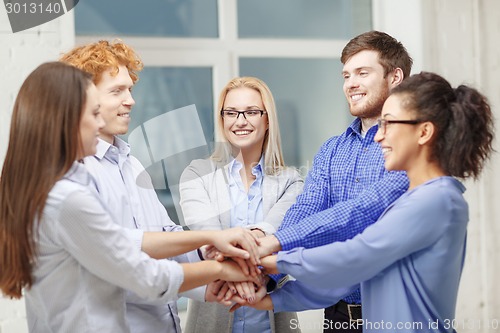 Image of team with hands on top of each other in office