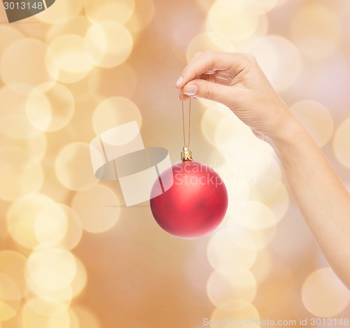 Image of close up of woman in sweater with christmas ball