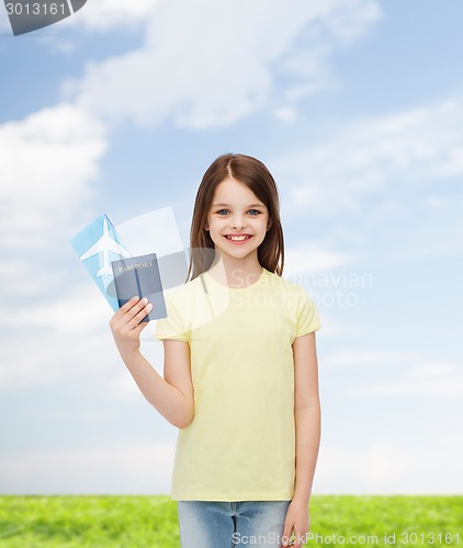 Image of smiling little girl with ticket and passport