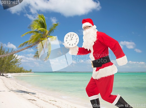 Image of man in costume of santa claus with clock