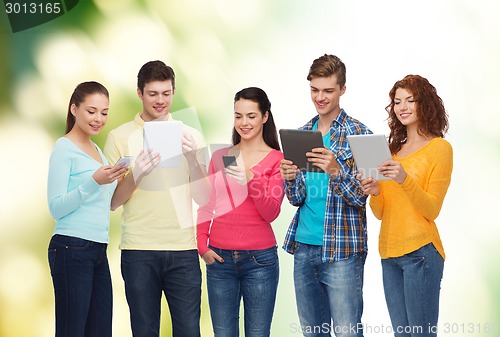 Image of group of teenagers with smartphones and tablet pc