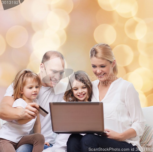 Image of happy family with laptop computer and credit card