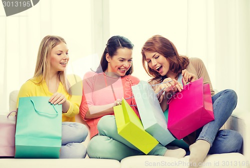 Image of smiling teenage girls with many shopping bags