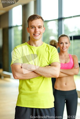 Image of smiling man and woman in gym