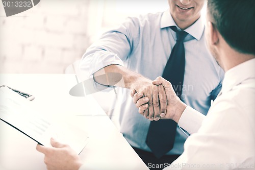 Image of businessmen shaking hands in office