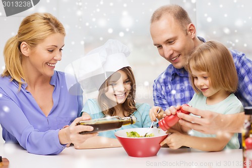 Image of happy family with two kids making salad at home