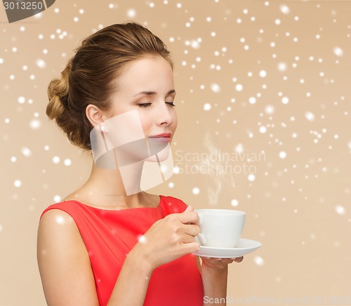 Image of smiling woman in red dress with cup of coffee