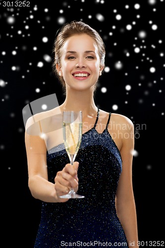 Image of smiling woman holding glass of sparkling wine