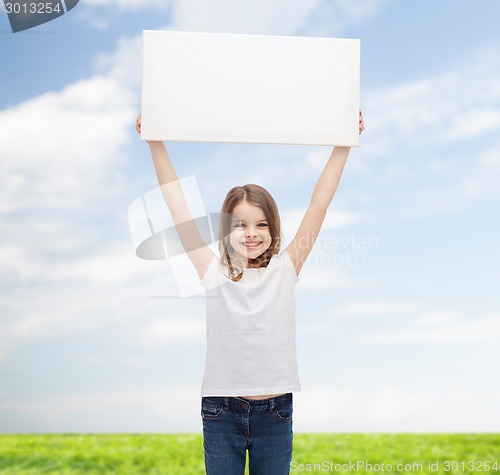 Image of smiling little girl holding blank white board