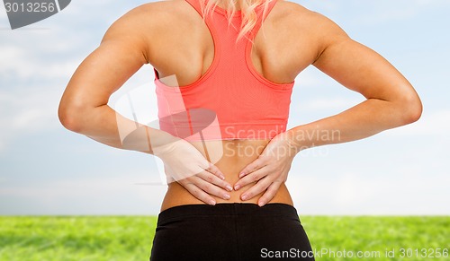 Image of close up of sporty woman touching her back