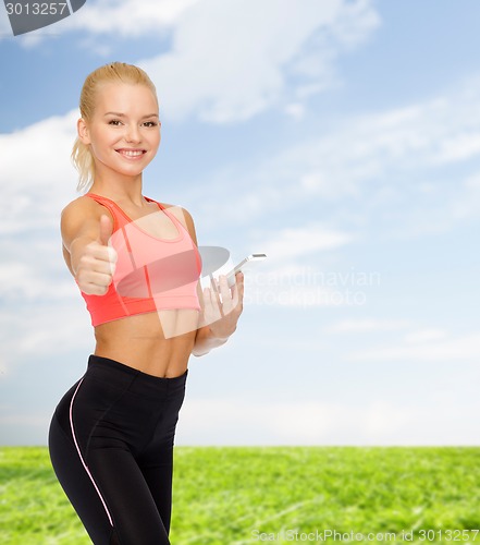 Image of smiling sporty woman with smartphone