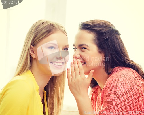 Image of one girl telling another secret