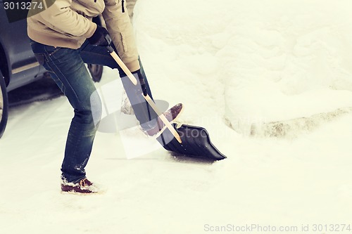 Image of closeup of man shoveling snow from driveway